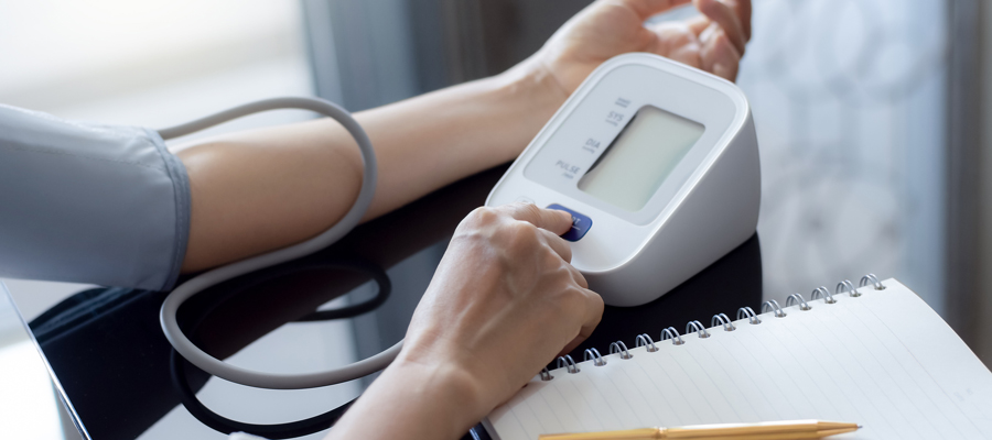 Mujer tomándose la tensión con un tensiómetro. 