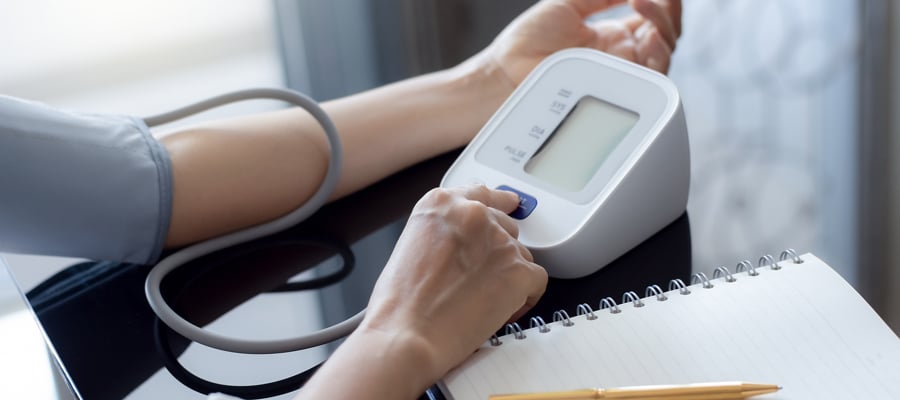 Mujer tomándose la tensión con un tensiómetro.