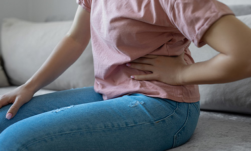 Mujer se toca la barriga ya que le duele el hígado