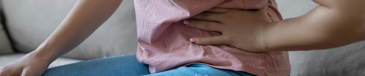 Mujer se toca la barriga ya que le duele el hígado