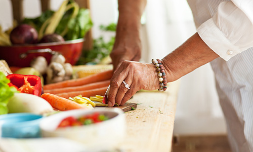 Mujer mayor cocina alimentos saludables por su intolerancia al gluten