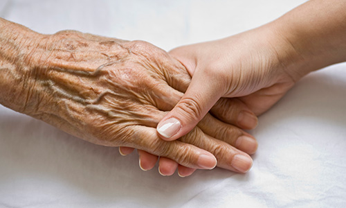 Mano anciana y joven se cogen 