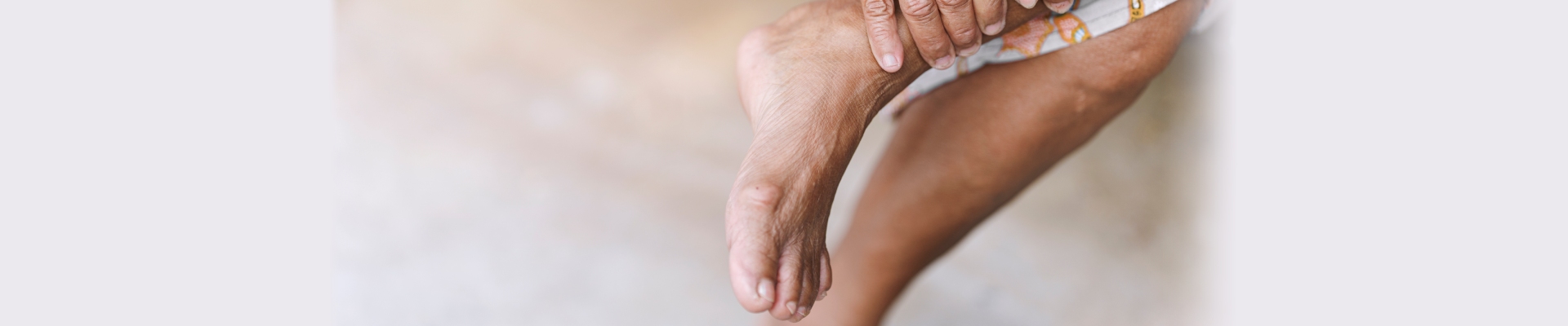 Mujer mayor tocándose los pies porque los tiene doloridos por las ampollas en los pies.