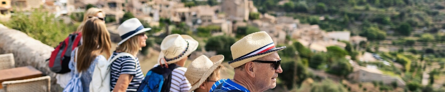 Grupo de personas mayores mirando desde un mirador las hermosas vistas de un paraje español, el cual han venido a visitar con la Imserso.